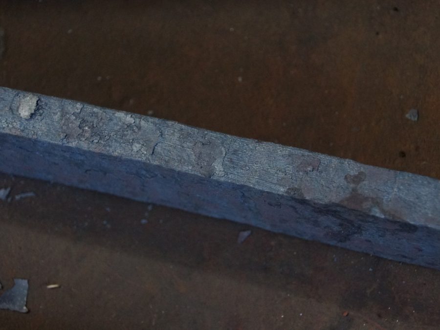 Close-up of a forged plain carbon steel bar with oxide finish