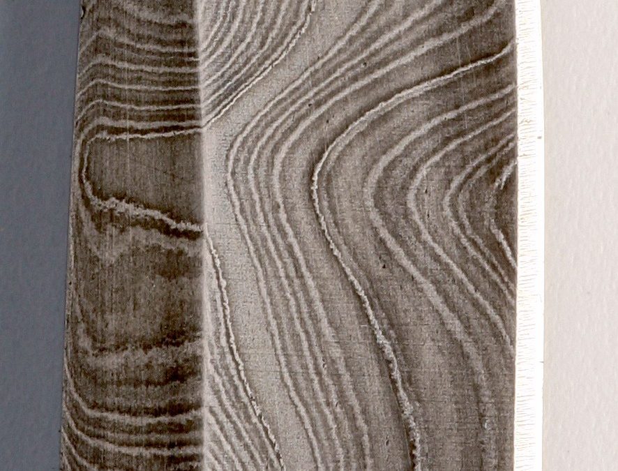 Close-up of ladder-pattern Damascus steel showing layered grain