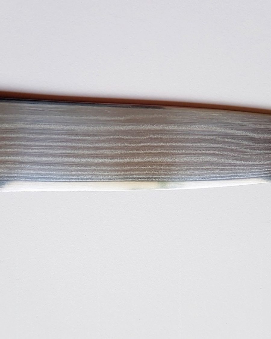 Close-up of a Damascus kitchen knife blade with fine wavy pattern