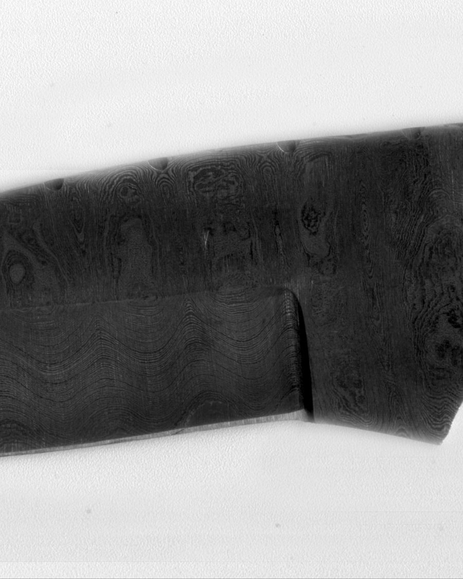 Close-up of dark mottled pattern-welded Damascus steel