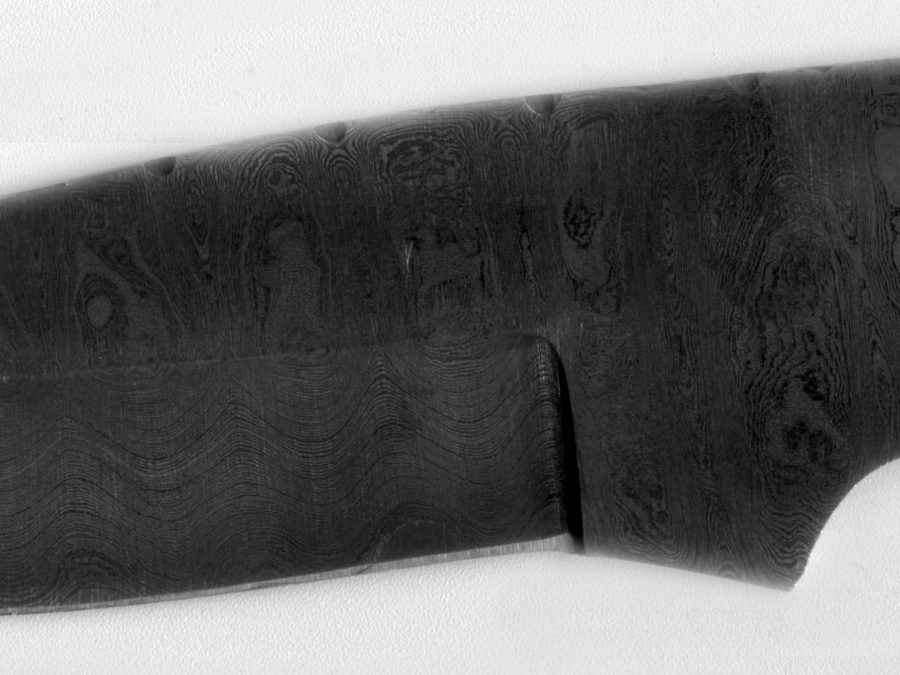 Close-up of dark mottled pattern-welded Damascus steel